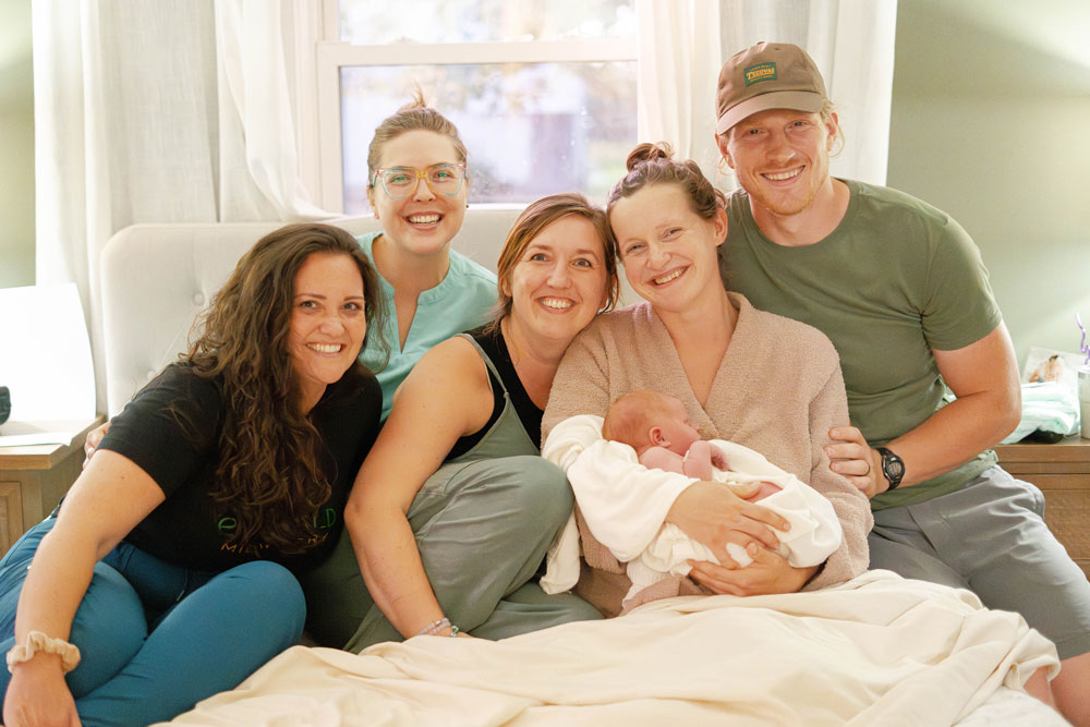 Emerald Midwifery team with family holding their newborn who just had a home birth.